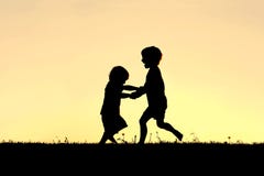 Silhouet van Gelukkige Kleine Kinderen die bij Zonsondergang dansen stock afbeelding Silhouet van Gelukkige Kleine Kinderen die bij Zonsondergang dansen stock afbeelding
