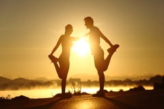 Silhouet van zich geschiktheidspaar het uitrekken bij zonsondergang Stock Fotografie Silhouet van zich geschiktheidspaar het uitrekken bij zonsondergang Stock Fotografie
