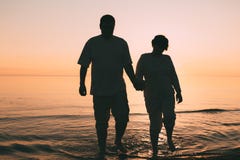 Silhouette of adult couple standing in the sea against a sunset. Evening photo Stock Photography Silhouette of adult couple standing in the sea against a sunset. Evening photo Stock Photography