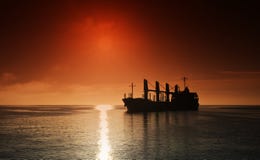 Silhouette of the cargo ship over the sunrise stock images Silhouette of the cargo ship over the sunrise stock images