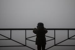 silhouette of a child holding handrail and looking towards fog mist royalty free stock photography silhouette of a child holding handrail and looking towards fog mist royalty free stock photography