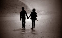 Silhouette of couple walking on a beach. Stock Photos Silhouette of couple walking on a beach. Stock Photos