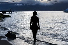 Silhouette d'une femme sur la plage au coucher du soleil photos libres de droits Silhouette d'une femme sur la plage au coucher du soleil photos libres de droits