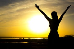 Silhouette d'une fille soulevant des mains au ciel après la formation physique, une femme appréciant le coucher du soleil image libre de droits Silhouette d'une fille soulevant des mains au ciel après la formation physique, une femme appréciant le coucher du soleil image libre de droits