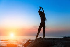 Silhouette of dancing young slim woman on the ocean coast during an sunset. Silhouette of dancing young slim woman on the ocean coast during an amazing sunset Royalty Free Stock Photos Silhouette of dancing young slim woman on the ocean coast during an sunset. Silhouette of dancing young slim woman on the ocean coast during an amazing sunset Royalty Free Stock Photos