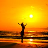 Silhouette de jeune femme sur la plage dans le coucher du soleil d'été Images libres de droits Silhouette de jeune femme sur la plage dans le coucher du soleil d'été Images libres de droits