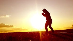 Silhouette de l'homme exerçant la boxe thaïlandaise La silhouette des arts martiaux équipent la boxe de formation sur la plage au Silhouette de l'homme exerçant la boxe thaïlandaise La silhouette des arts martiaux équipent la boxe de formation sur la plage au
