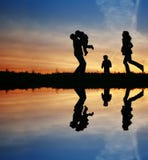 Silhouette family of four. And water Silhouette family of four. And water