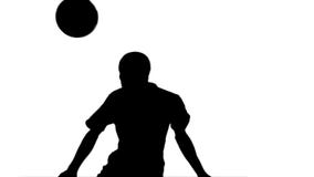 Silhouette of football player heading the ball