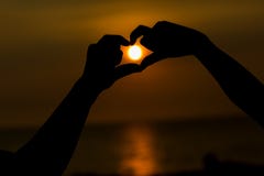 Silhouette of hands making a heart shaped symbol with beautiful sunset background. stock photos Silhouette of hands making a heart shaped symbol with beautiful sunset background. stock photos