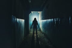 Silhouette of man maniac or killer or horror murderer with knife in hand in dark creepy and spooky corridor. Criminal robber stock photography Silhouette of man maniac or killer or horror murderer with knife in hand in dark creepy and spooky corridor. Criminal robber stock photography