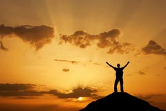Silhouette of a man on a mountain top against the sunset sky. Sport and active life concept Stock Photo Silhouette of a man on a mountain top against the sunset sky. Sport and active life concept Stock Photo