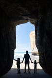 Silhouette of mother with two kids in a cave at Tunnel beach Stock Photo Silhouette of mother with two kids in a cave at Tunnel beach Stock Photo
