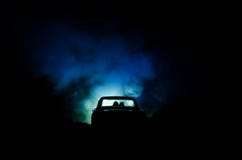 Silhouette Of Car With Couple Inside On Dark Background With Lights And Smoke. Romantic Scene. Love Concept Royalty Free Stock Photo