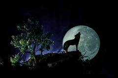 Silhouette Of Howling Wolf Against Dark Toned Foggy Background And Full Moon Or Wolf In Silhouette Howling To The Full Moon. Hallo Royalty Free Stock Photography Silhouette Of Howling Wolf Against Dark Toned Foggy Background And Full Moon Or Wolf In Silhouette Howling To The Full Moon. Hallo Royalty Free Stock Photography