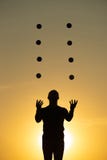 Silhouette Of Juggler With Balls On Colorful Sunset Stock Images