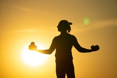 Silhouette Of Juggler With Balls On Colorful Sunset Stock Photography