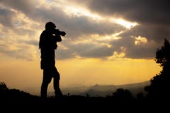 Silhouette of a photographer who shoots a sunset royalty free stock images Silhouette of a photographer who shoots a sunset royalty free stock images