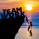 Silhouette teamwork of people climbs into cliff to reach the word TEAM WORK with sunrise stock images Silhouette teamwork of people climbs into cliff to reach the word TEAM WORK with sunrise stock images