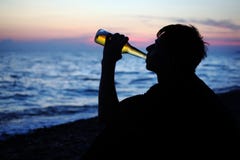 Silhouette teenager boy drinking beer on seacoast royalty free stock photography Silhouette teenager boy drinking beer on seacoast royalty free stock photography
