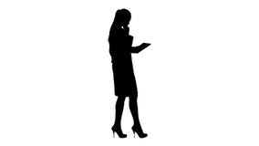 Silhouette Woman doctor using tablet pc and walking. stock photo Silhouette Woman doctor using tablet pc and walking. stock photo
