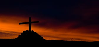 The silhouette of wooden cross on fiery sky background stock images The silhouette of wooden cross on fiery sky background stock images