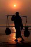 Silhouette of worker walking on the beach during sunset