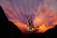 Silhouette of yoga of woman practising outdoors in mountains on a sunset
