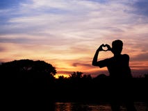 Silhouette of young man forming hand to heart shape stock photography Silhouette of young man forming hand to heart shape stock photography
