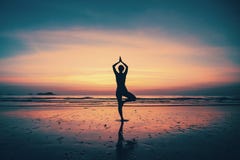 Silhouette young woman practicing yoga on the beach Royalty Free Stock Photos Silhouette young woman practicing yoga on the beach Royalty Free Stock Photos