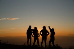 The silhouette of a young woman is standing on the top of a mountain that is relaxed by the sun at sunrise from the sunrise. royalty free stock images The silhouette of a young woman is standing on the top of a mountain that is relaxed by the sun at sunrise from the sunrise. royalty free stock images