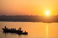 Silhouettes of Boats with pilgrims during sunset on the Holy Ganges river in Varanasi stock images Silhouettes of Boats with pilgrims during sunset on the Holy Ganges river in Varanasi stock images