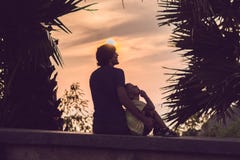 Silhouettes of the father and son, who meet the sunset in the tropics against the backdrop of palm trees royalty free stock photos Silhouettes of the father and son, who meet the sunset in the tropics against the backdrop of palm trees royalty free stock photos