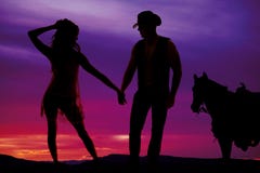 Silhouetvrouw in zuivere kleding met cowboy en paard stock foto Silhouetvrouw in zuivere kleding met cowboy en paard stock foto