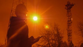 Silhueta de um coordenador no por do sol, que olha as colunas da telecomunicação O coordenador redige dados à tabuleta E video estoque Silhueta de um coordenador no por do sol, que olha as colunas da telecomunicação O coordenador redige dados à tabuleta E video estoque