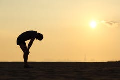 Silhueta de um desportista esgotado no por do sol foto de stock Silhueta de um desportista esgotado no por do sol foto de stock