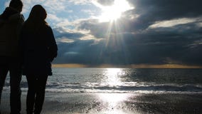 Silhueta de um homem e de uma mulher que guardam suas mãos na perspectiva do mar filme Silhueta de um homem e de uma mulher que guardam suas mãos na perspectiva do mar filme