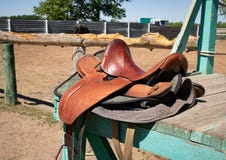 Silla de montar del caballo en el tablero de madera, fondo de la granja foto de archivo Silla de montar del caballo en el tablero de madera, fondo de la granja foto de archivo