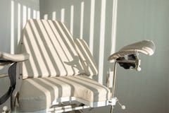Silla ginecológica Tiras de la luz de la mañana a través de las persianas Oficina médica para el examen de mujeres en el hospital foto de archivo Silla ginecológica Tiras de la luz de la mañana a través de las persianas Oficina médica para el examen de mujeres en el hospital foto de archivo
