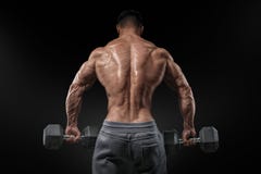 Silny bodybuilder robi ćwiczeniom z dumbbells obracającymi z powrotem fotografia stock Silny bodybuilder robi ćwiczeniom z dumbbells obracającymi z powrotem fotografia stock