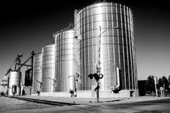 Silos on Railroad Tracks in Wall, South Dakota. Black and white view of huge metal Silos sit alongside the railroad tracks waiting for hopper cars to load Stock Photo Silos on Railroad Tracks in Wall, South Dakota. Black and white view of huge metal Silos sit alongside the railroad tracks waiting for hopper cars to load Stock Photo