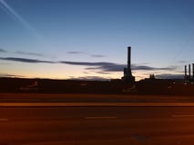 Silueta de la chimenea de la fábrica en la salida del sol fotografía de archivo Silueta de la chimenea de la fábrica en la salida del sol fotografía de archivo