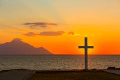 Silueta de la cruz en la salida del sol o de la puesta del sol con los rayos ligeros y el panorama del mar Fotografía de archivo Silueta de la cruz en la salida del sol o de la puesta del sol con los rayos ligeros y el panorama del mar Fotografía de archivo