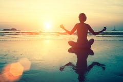 Silueta de la yoga Muchacha de la meditación en el mar durante puesta del sol fotografía de archivo libre de regalías Silueta de la yoga Muchacha de la meditación en el mar durante puesta del sol fotografía de archivo libre de regalías