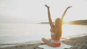 Silueta de la yoga practicante de la mujer joven en la costa con el fondo de la puesta del sol almacen de video Silueta de la yoga practicante de la mujer joven en la costa con el fondo de la puesta del sol almacen de video