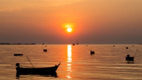 Silueta de pequeñas naves en el mar en el tiempo crepuscular con Sun y la reflexión hermosos imagen de archivo Silueta de pequeñas naves en el mar en el tiempo crepuscular con Sun y la reflexión hermosos imagen de archivo