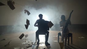 Siluetas de los m?sicos que juegan y hojas que caen, humo en fondo en slowmo Siluetas de los m?sicos que juegan y hojas que caen, humo en fondo en slowmo