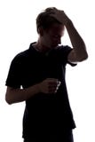 Siluetee el retrato de un individuo elegante, controles del hombre joven su mano a través de su pelo de un fondo aislado blanco imagen de archivo Siluetee el retrato de un individuo elegante, controles del hombre joven su mano a través de su pelo de un fondo aislado blanco imagen de archivo