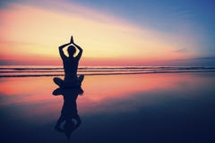 Siluetee la yoga practicante de la mujer joven en la playa del mar en la puesta del sol surrealista Naturaleza imagenes de archivo Siluetee la yoga practicante de la mujer joven en la playa del mar en la puesta del sol surrealista Naturaleza imagenes de archivo