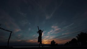 Siluetta di una ballerina che balla sulla punta dei piedi contro il cielo di tramonto archivi video Siluetta di una ballerina che balla sulla punta dei piedi contro il cielo di tramonto archivi video